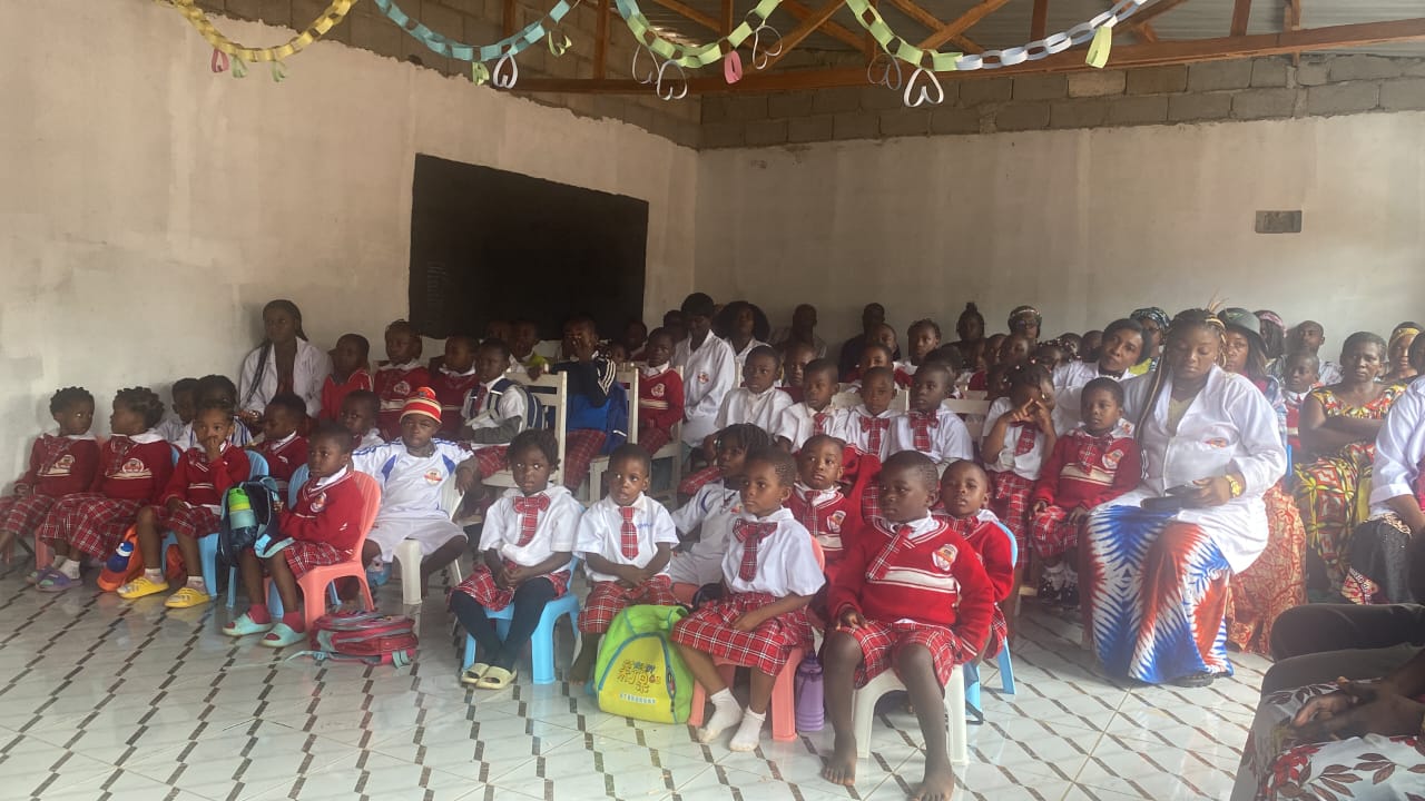 Enfants et parents réunis en salle de classe décorée pour une cérémonie